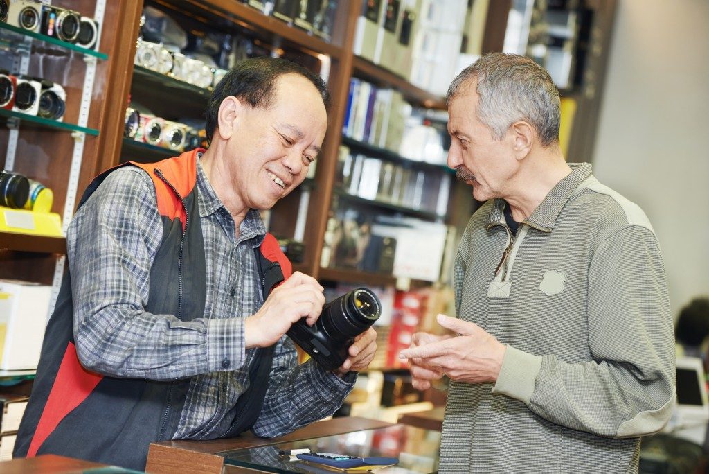 Shop owner explaining camera specs to a potential customer