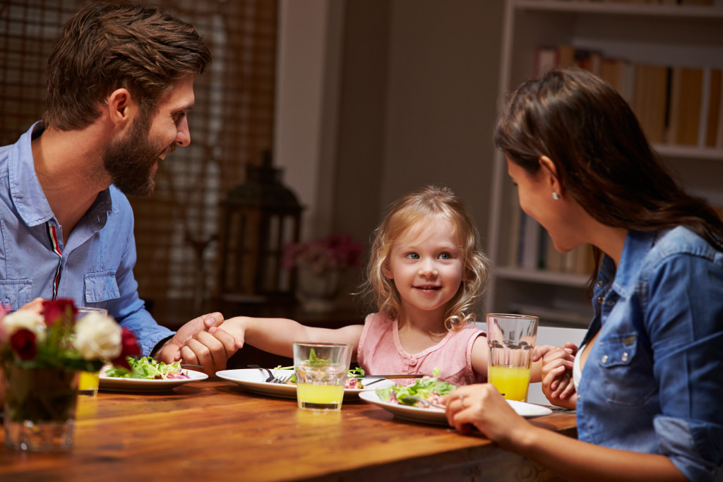 Young couple eating dinner with their daughter at home